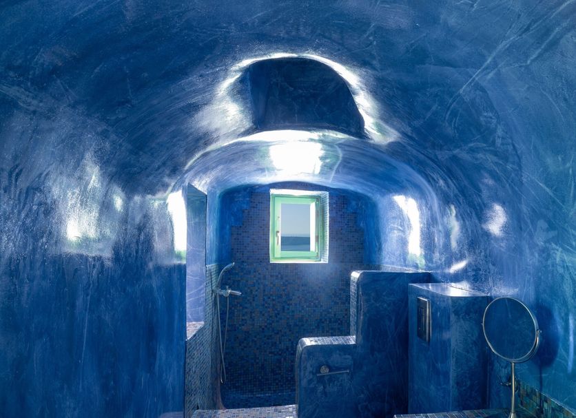 Dreams Luxury Suites in Imerovigli: blue cave-style suite bathroom with arched ceiling and window