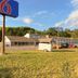 Motel 6 Norway MI exterior with roadside sign, parking lot and wooded backdrop in Norway