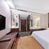 Elite Hotel Xi'an in Xi'an guest room with king bed, TV, wood desk and glass-enclosed bathroom