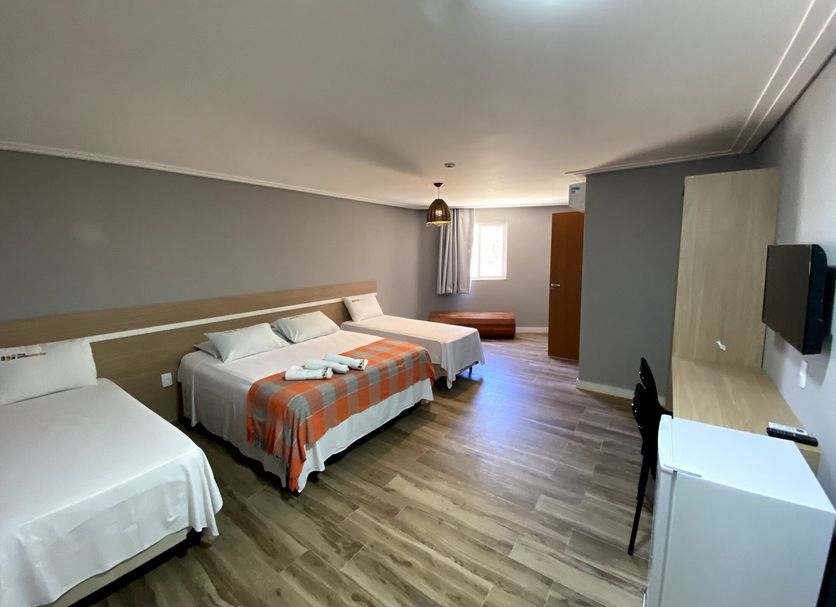 Hotel Porto Salvador in Salvador guest room with three beds, desk, wardrobe and window