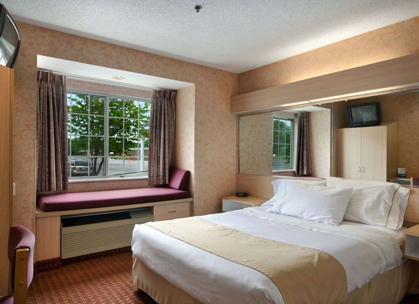 Microtel Inn & Suites by Wyndham Baldwinsville/Syracuse guest room with bed, window seat and TV