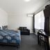 Castle Motel Bairnsdale room with queen bed, sofa, desk, and large window
