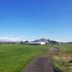 Hagi 1 Guesthouse in Husavik beside a grassy field and gravel path under a clear blue sky