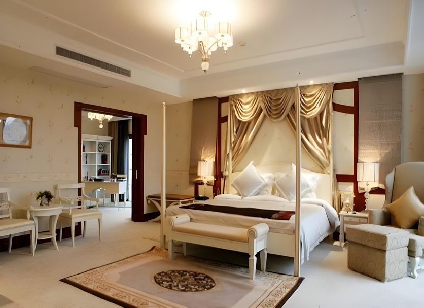 Pengxin Garden Guobin Hotel in Nantong: elegant suite with canopy bed, chandelier, seating area