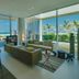 Al Zorah Beach Resort, Ajman: ocean-view suite with floor-to-ceiling windows, seating area, and balcony