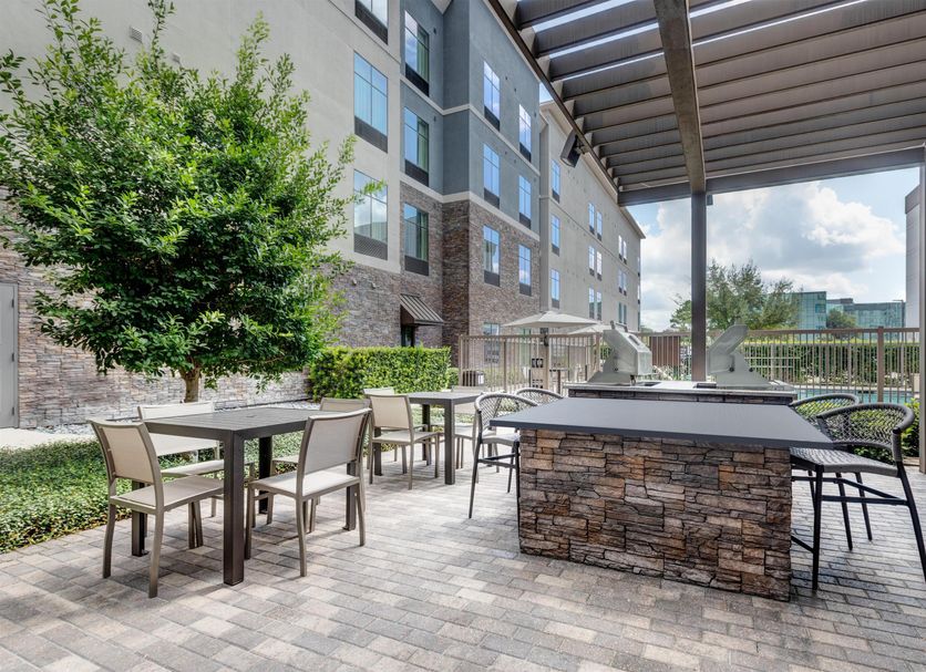 Outdoor patio seating area at Homewood Houston Memorial in Houston with tables, chairs, and stone bar