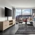 Loews Arlington Hotel suite with sofa, TV, and balcony view of Arlington stadium