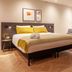 Golden Tulip Leiden Centre guest room with king bed, sofa, armchair, and floor lamp