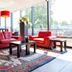 Bastion Hotel Barendrecht lounge with red sofas, patterned rug and large windows
