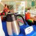 Hotel Peten, Flores breakfast station with coffee thermos, milk sign, cups, and sugar packets