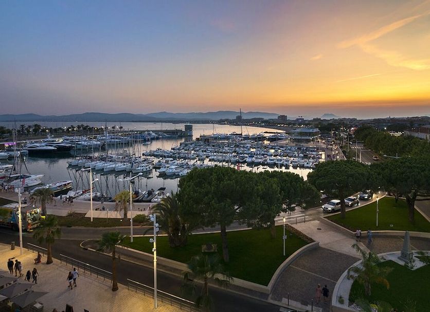 Hotel Le Touring in Saint-Raphaël overlooking a marina and harbor at sunset