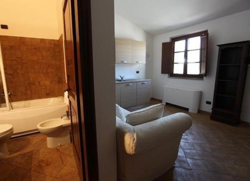 Agriturismo Lapone in Orvieto: bathroom with tub, bidet, and adjacent living area with sofa and window