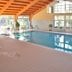Indoor pool at Hotel Hajnal in Mezőkövesd with large windows and wood-beamed ceiling