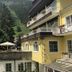Hotel Lindenhof in Bad Gastein with mountain views, terraces, umbrellas and a yellow exterior