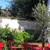 Villa Rambouillet in Rambouillet: outdoor terrace with red chairs, wooden table and greenery