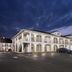 Baymont by Wyndham Tuscaloosa exterior at dusk with two-story white facade and parking lot
