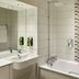 Premier Inn Milton Keynes South bathroom with bathtub, shower, sink and tiled accent wall in Milton Keynes