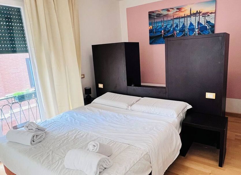 L'Affittacamere di Venezia room with double bed, balcony door, and bedside tables in Venice