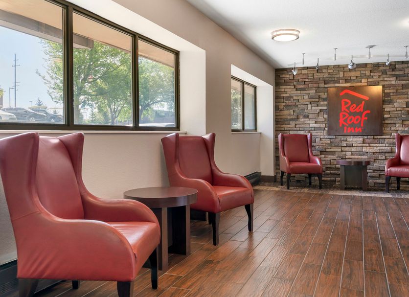 Red Roof Inn Detroit-Rochester Hills/Auburn Hills lobby seating area with red chairs and wood floors