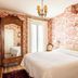 Hôtel de l'Abeille in Orléans bedroom with toile wallpaper, ornate armoire, wall TV and white bed