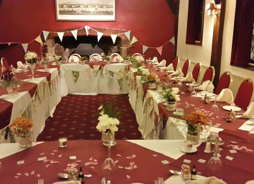 Roebuck Inn Stevenage banquet room set for a formal event with U-shaped tables and red chairs
