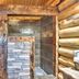 Hibernation Station in West Yellowstone bathroom with log walls, stone shower, and toilet