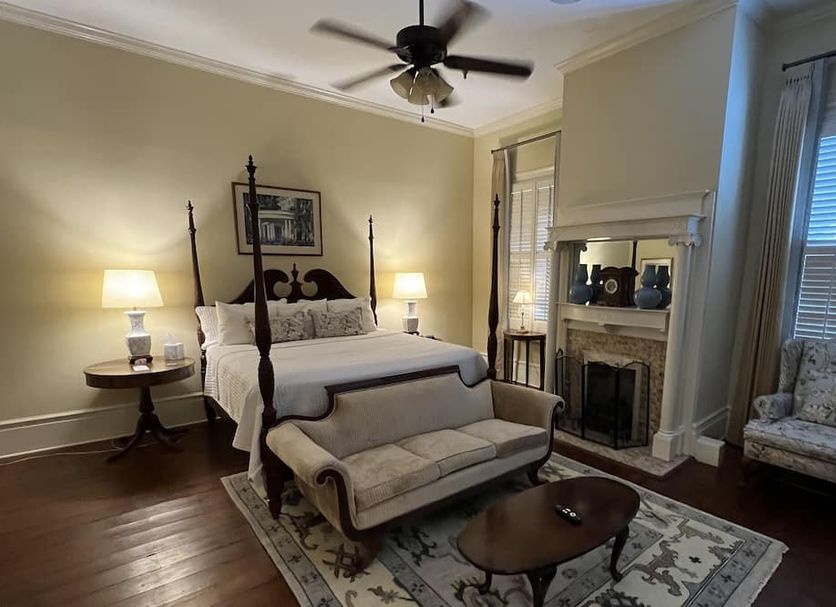 1842 Inn in Macon: elegant four-poster bedroom with fireplace, sitting area, and patterned rug