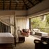 Four Seasons Safari Lodge Serengeti bedroom with canopy bed and private terrace overlooking savanna