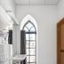 Piano Apartments in Kaunas bathroom with arched window, sink, and shower curtain