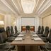 Riviera Rayhaan by Rotana Doha boardroom with a long conference table, black chairs, and chandelier