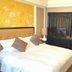 Ramada Plaza by Wyndham Tian Lu Hotel Wuhan guest room with king bed, floral accent wall and black wardrobe