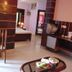 Ganga Beach Resort in Rishikesh room with chair, table, bed, and compact kitchenette