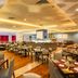 Pestana Curitiba restaurant dining area with tables, chairs, and warm ambient lighting