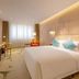 Guanganmen Grand Metropark Hotel Beijing guest room with king bed, chair by window, and wall-mounted TV