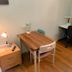 Westside Studio Apartments in Armidale with a wooden desk, chair, nightstand lamp, and small workspace