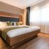 Sporthotel Grafenwald in Daun guest room with king bed, warm wood accents and large window