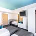 B&B Hotel München City-Ost room in Munich with two beds, wall-mounted TV and turquoise ceiling