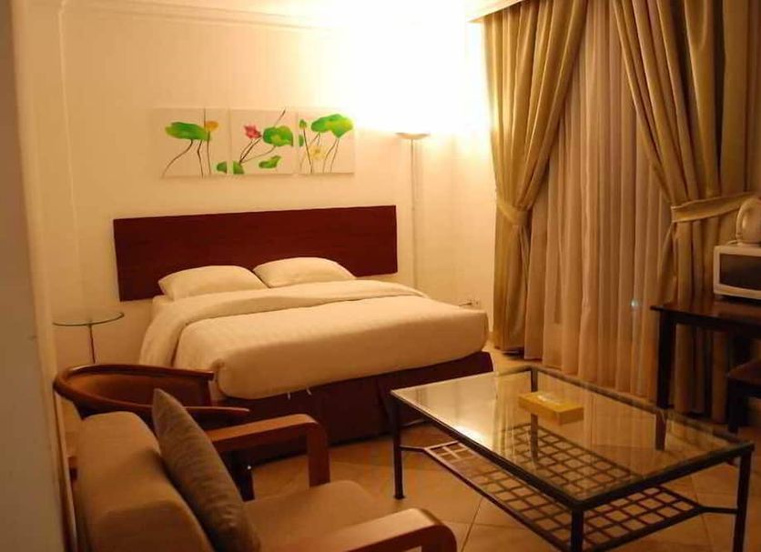 Times Square Suite Hotel in Ḩawallī: simple bedroom with double bed, glass coffee table and curtains