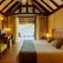 Maitai Rangiroa Avatoru guest room with vaulted wood ceiling, king bed, desk and patio doors to terrace