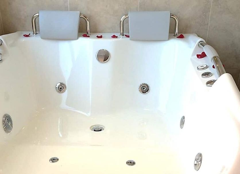 Hotel Boutique Feria Internacional Bogotá bathroom with white whirlpool tub and headrests
