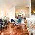 Teichnersuite Rome living room with blue sofa, dining table, polished wood floors and arched ceiling