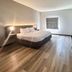 Studio 6 Suites Elkhart, IN guest room with king bed, TV, and wood-look flooring
