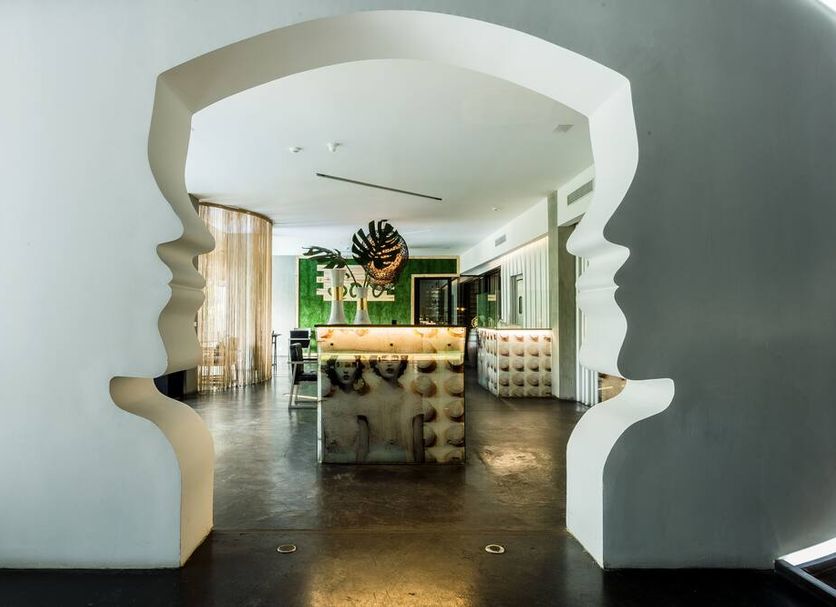Riande Urban Hotel lobby in Panama City with sculptural doorway, central bar, and modern seating