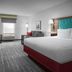 Hampton Inn Yorkville guest room with king bed, desk, sofa, and window seating area