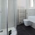 Bathroom at limehome Baden-Baden Bäderstraße in Baden-Baden with shower, toilet and window.