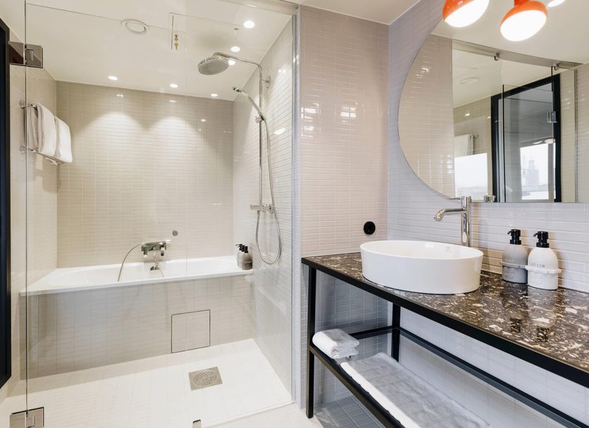 Hobo, an Ascend Collection Hotel Stockholm bathroom with tub, walk-in shower, vessel sink and mirror