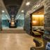 Sky Blue Hotel & Spa Ploieşti spa corridor with stone walls, lounge seating and warm-lit treatment rooms