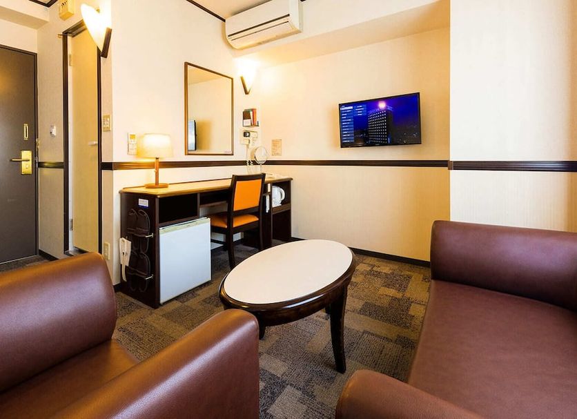 Toyoko Inn Keio sen Hashimoto eki Kita guchi room with desk, TV, sofa seating and oval table in Sagamihara