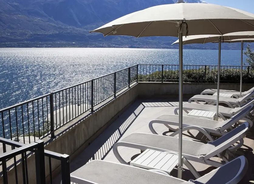 Hotel Atilius Adults Only terrace with loungers and lake view in Limone sul Garda