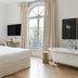 Hotel Tayko Sevilla room with freestanding bathtub, arched window and bed in Seville